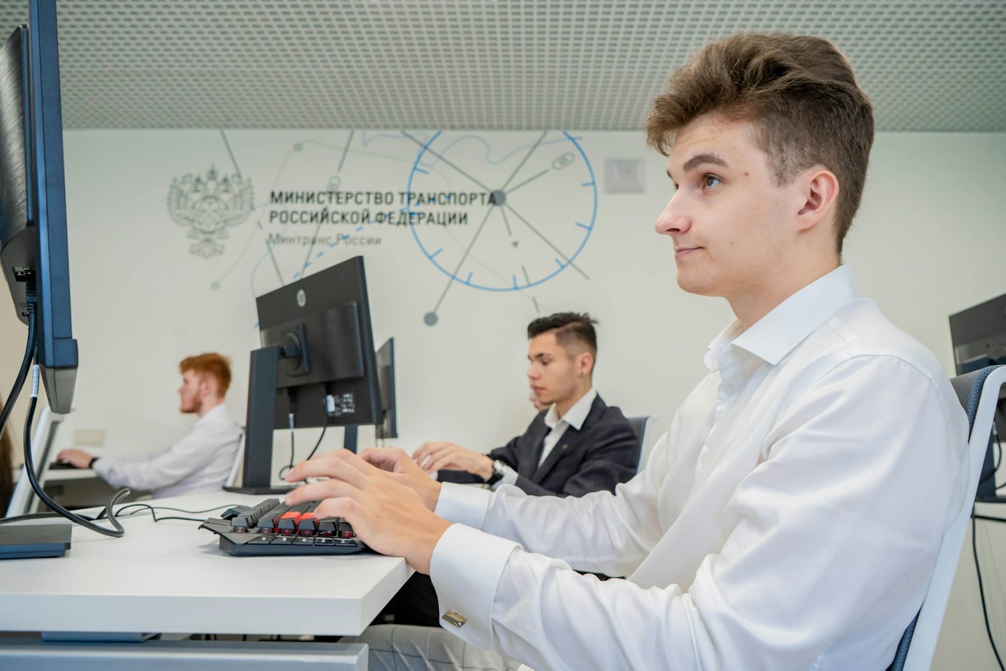 Tre studenti lavorano al computer in un ufficio moderno.